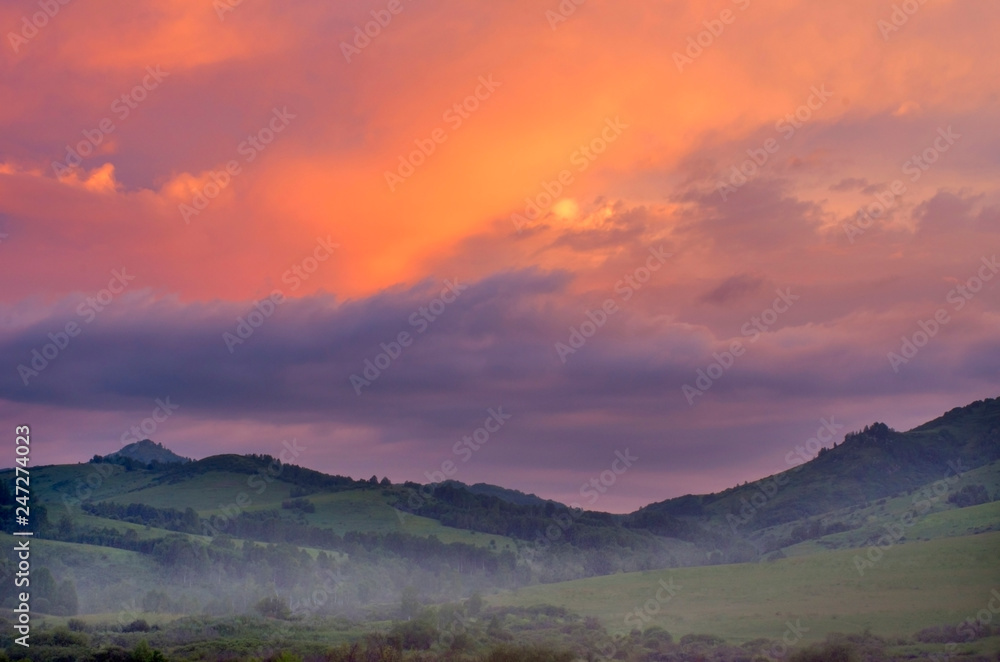 Dramatic Vibrant Sunrise over Misty Hills on a Summer Morning, Altai Mountains, Kazakhstan.  Fantasyland, New Day, Traveling, Blue Hour Concept.