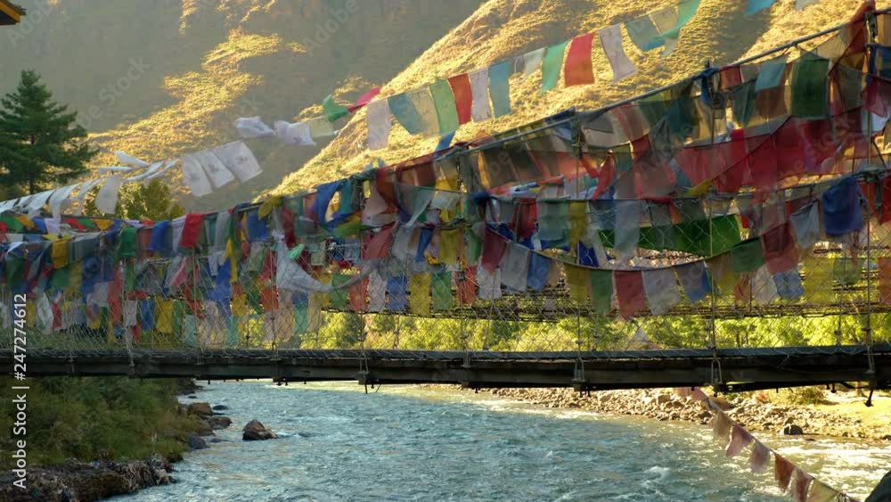 Suspension bridge covered in prayer flags near Paro, Bhutan Suspension bridge covered in prayer flags near Paro, Bhutan