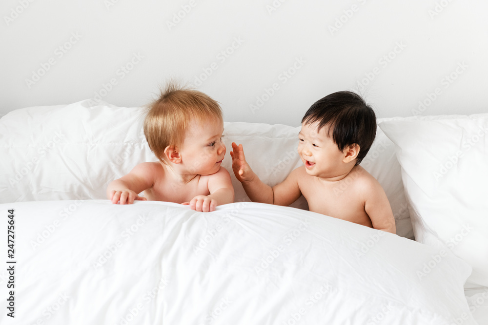 Babies playing on the bed Babies playing on the bed