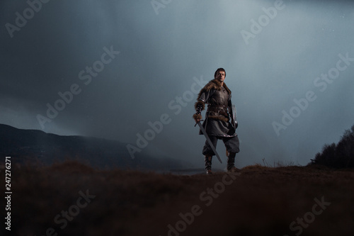 Obraz na plátne Medieval knight with sword and spear in ancient armour over Winter Landscapes