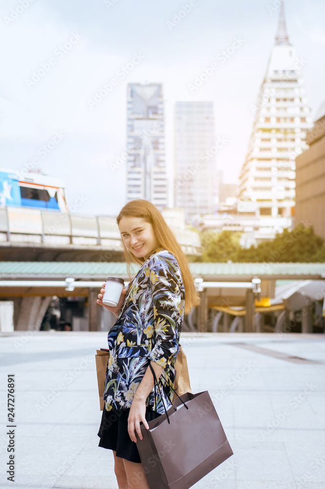 Portrait of beautiful caucasian woman smling and holding shopping bags in city,Lifestyle concept