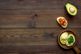 Healthy snacks. Set of toasts with vegetables like avocado, guacamole, rocket, cherry tomatoes on dark wooden background top view copy space