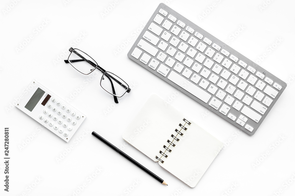 Office desk in order. Geometry. Computer keyboard and office supplies, glasses on white background top view copy space Office desk in order. Geometry. Computer keyboard and office supplies, glasses on white background top view copy space