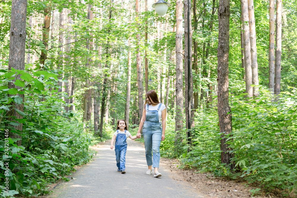 Family, nature, people concept - Young mother and cute daughter spend time together on a walk in the forest Family, nature, people concept - Young mother and cute daughter spend time together on a walk in the forest