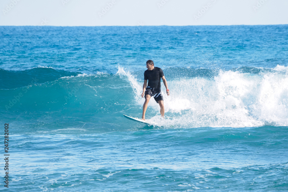 Surfer on blue Atlantic Ocean wave. Tropical winter. Shortboard. Surfer on blue Atlantic Ocean wave. Tropical winter. Shortboard.