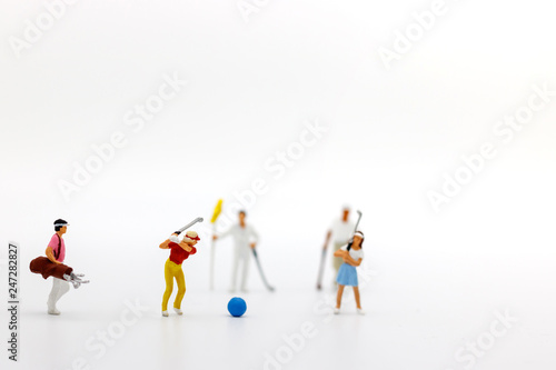 Miniature people: Golfers hit golf balls forward. Target and growth in business concept.