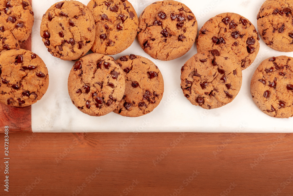 An overhead photo of freshly baked golden brown chocolate chip cookies, shot from the top on a dark rustic wooden background with copy space An overhead photo of freshly baked golden brown chocolate chip cookies, shot from the top on a dark rustic wooden background with copy space