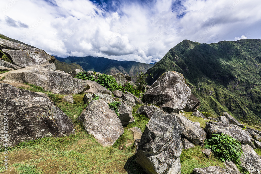 Stones on the slope of green mountains