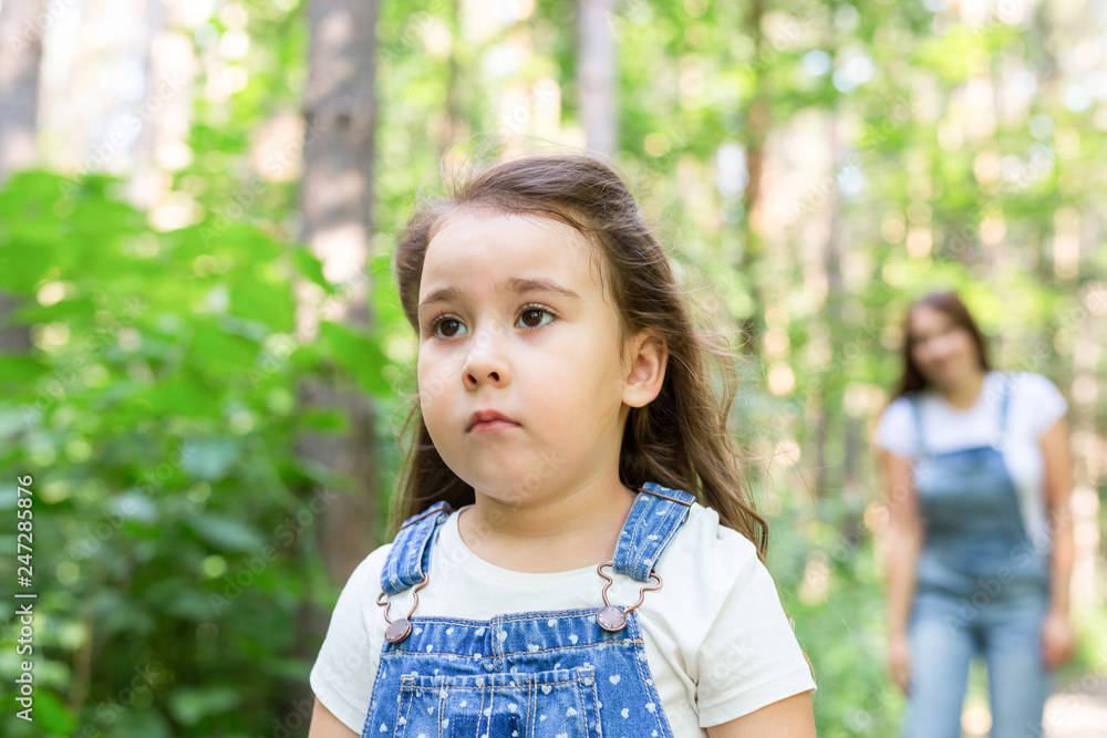 Family and nature concept - Close up portrait of offended child girl in the park Family and nature concept - Close up portrait of offended child girl in the park
