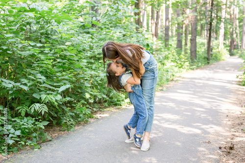 Family, nature, people concept - mother and daughter hugging in the park