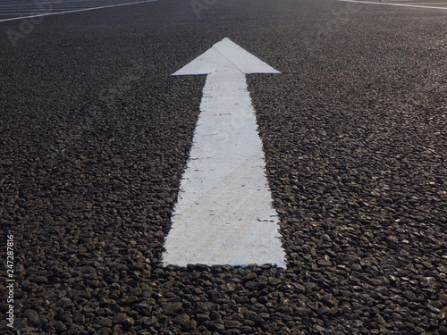 white arrow painted on asphalt