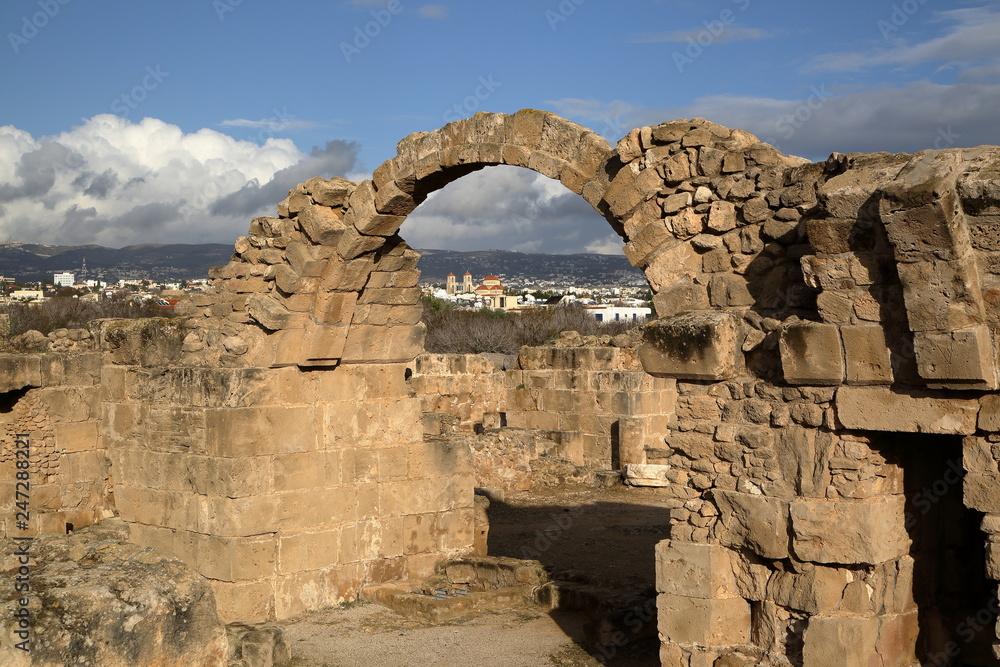 Saranda Kolonos castle ruins in Pafos Archaeological park, cyprus, in background buildings of city