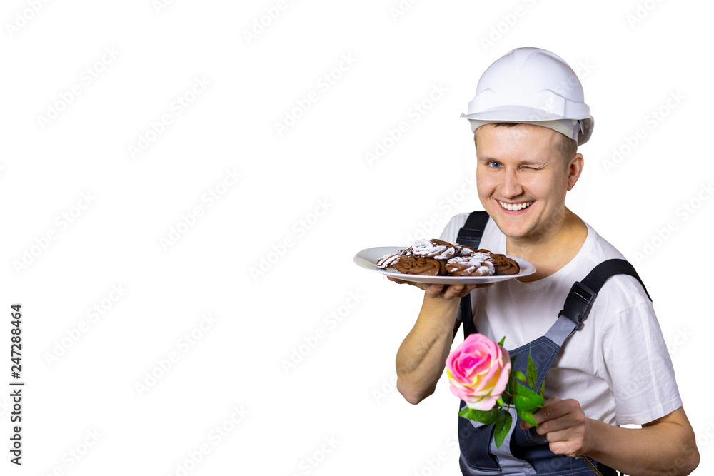 A young man dressed as a builder winks with eyes to congratulate women on the holiday. March 8, Women's International Day, anniversary, holiday. Isolated