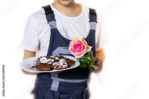 builder with a rose in their hands and cookies congratulates women or men on the holiday. March 8, International Women's Day, Valentine's Day, new year, anniversary, birthday, holiday. isolated. Blur