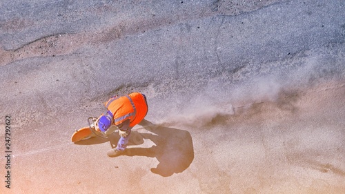Bilde på lerret Aerial view of unrecognizable road builder worker cutting asphalt or concrete with saw blade at construction site