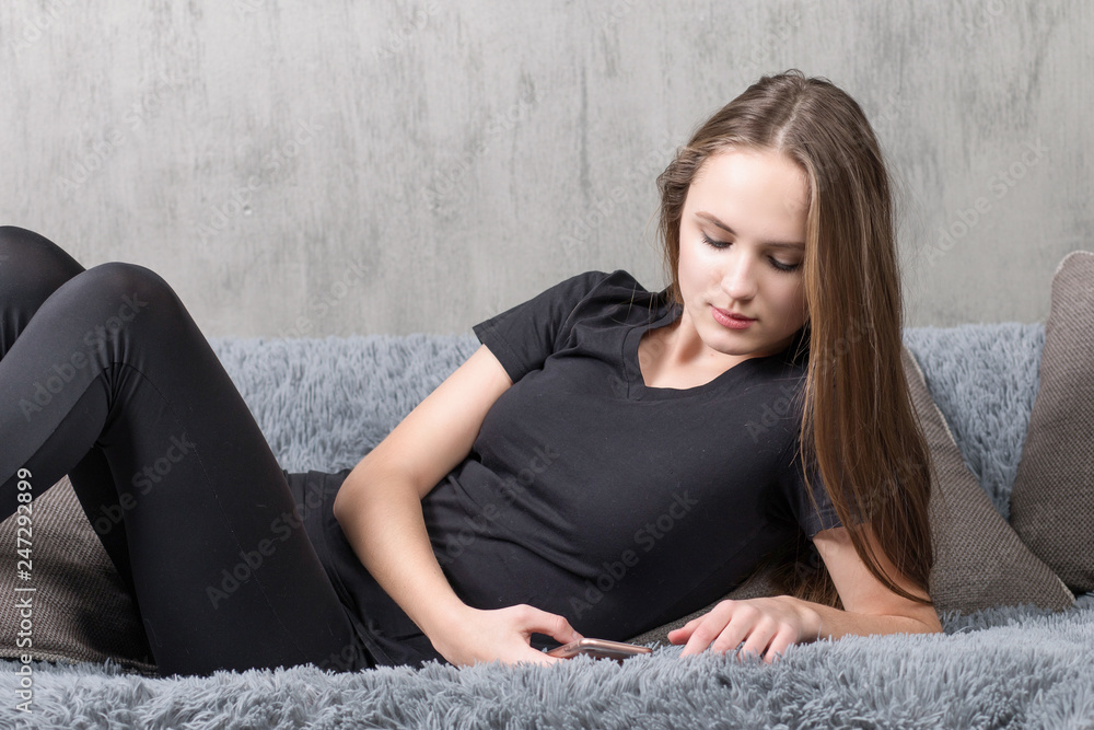 Smiling woman on sofa using smartphone Smiling woman on sofa using smartphone