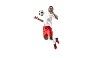 Professional african american football soccer player in motion isolated on white studio background. Fit jumping man in action, jump, movement at game.