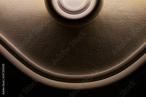 Fotografie Simplistic roundish sculptured wall design in creme brown color and black backgr