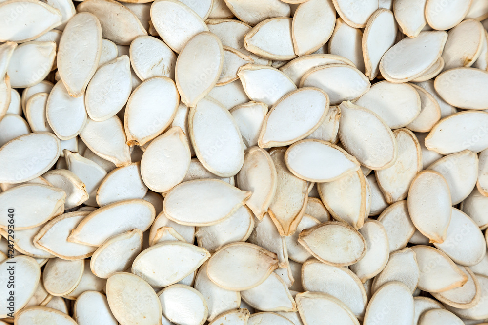  Unpeeled pumpkin seeds    pattern. Macro background texture of white pumpkin seeds