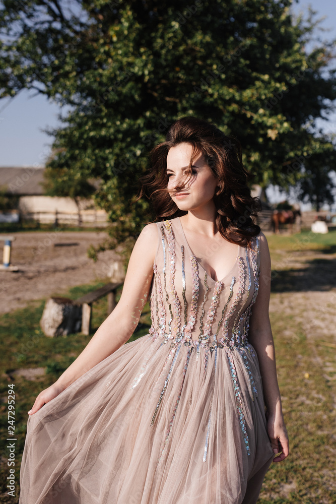 The bride in a delicate pink dress with paillettes on a brown horse. Wedding in the forest at sunset. Walking in the nature near the water. The bride in a delicate pink dress with paillettes on a brown horse. Wedding in the forest at sunset. Walking in the nature near the water.