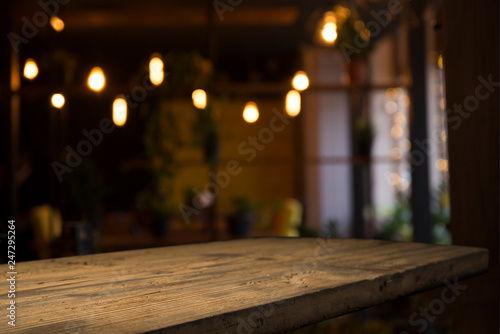 image of wooden table in front of abstract blurred background of resturant lights