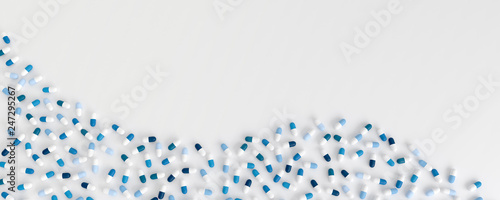 many blue pills poured in the shape of a wave on a white background, 3d illustration