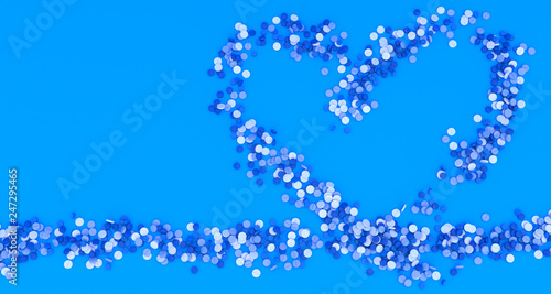 many blue pills poured in the shape of a heart on a blue background, 3d illustration