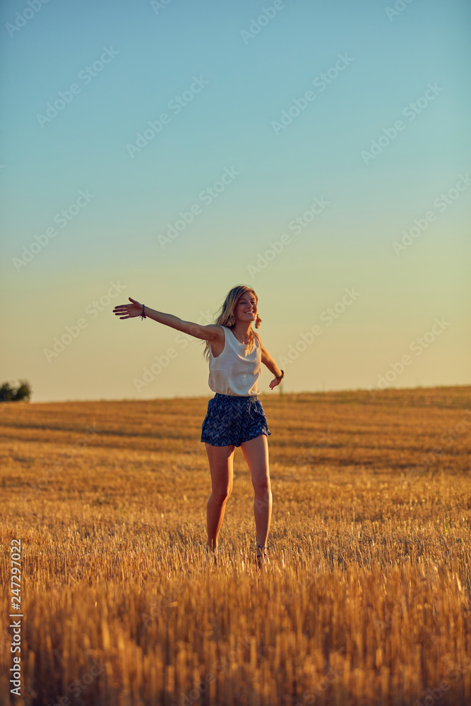 Cute young woman jumping in a wheat field. Cute young woman jumping in a wheat field.