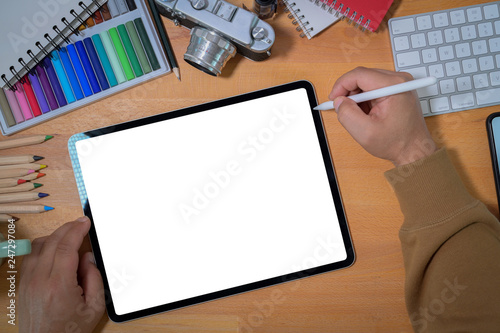Creative designer working with tablet device on wood workspace
