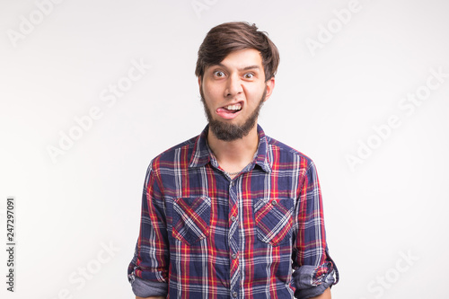Expression, april fools day and joke concept - Young funny bearded man sticks his tongue out