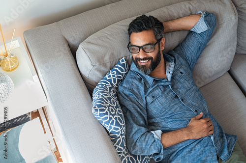 Mixed race man relaxing on couch photo