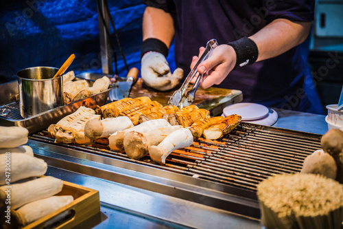 A food stalls selling grilled king oyster mushrooms on sticks at the Fengjia night market, Taiwan.