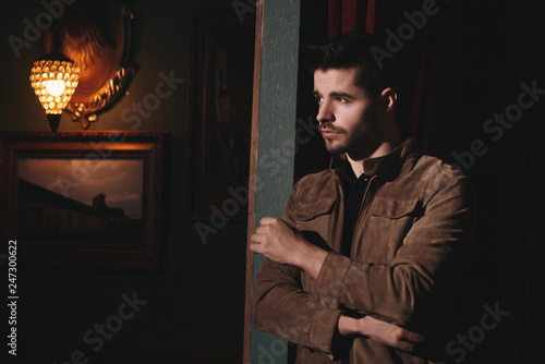 Young bearded male doing fashion shooting in vintage bar. 