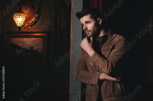 Young bearded male doing fashion shooting in vintage bar. 