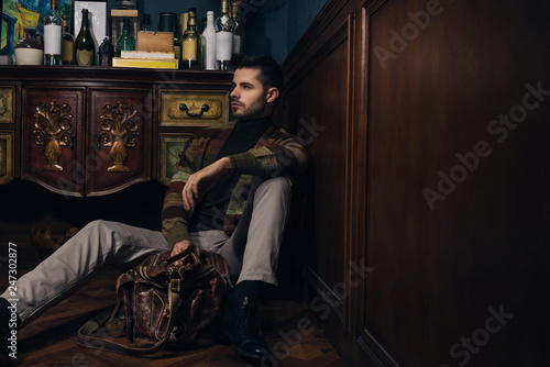 Young bearded male doing fashion shooting in vintage bar. 