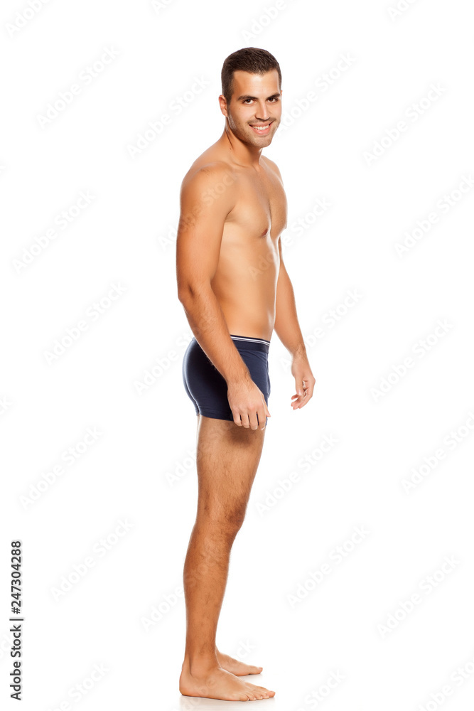 Shirtless handsome smiling man in panties on white background