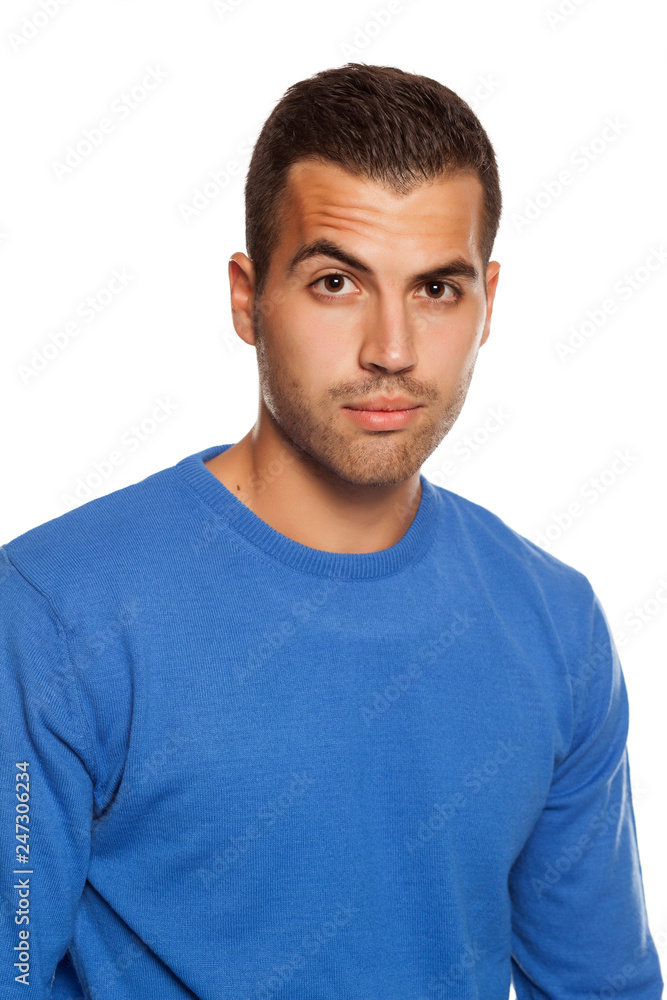 young man in blouse with skeptical look on white background young man in blouse with skeptical look on white background