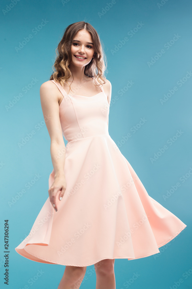 attractive slim woman dancing in studio in pink dress