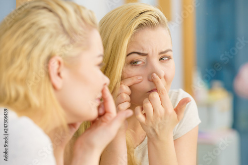 Woman looking at her skin in mirror