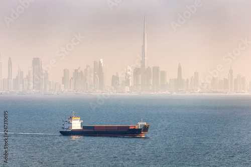 Canvas Print Cargo container ship and Dubai skyscrapers on a background