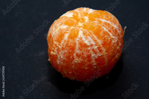 Fresh peeled mandarin orange on dark background
