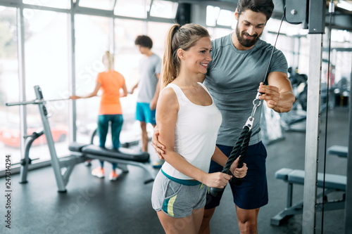 Young beautiful woman doing exercises with personal trainer