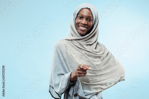 Photography The beautiful young black african muslim girl wearing gray hijab at blue studio