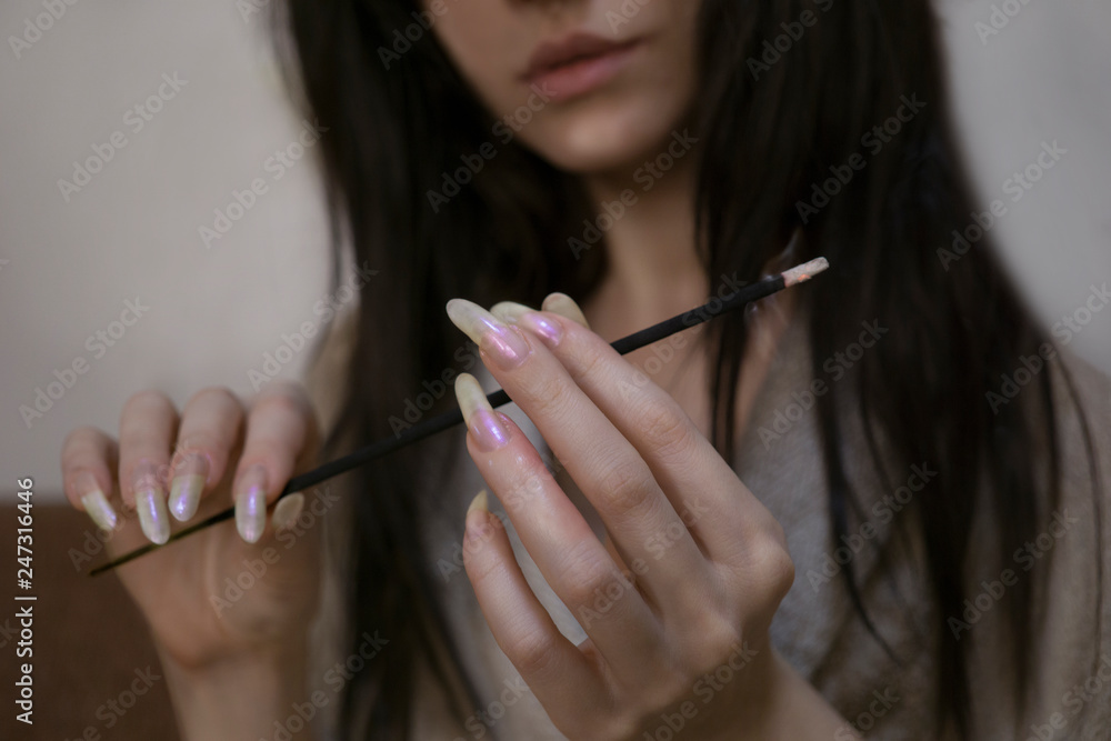 Obraz premium Sexy woman with long fingernails holding aroma incense