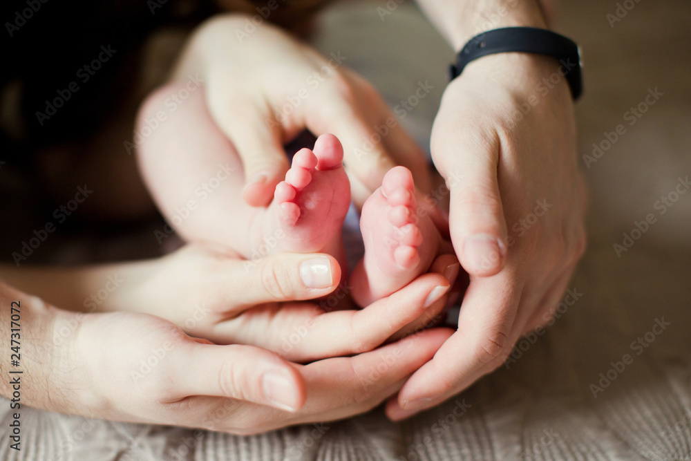 mother and father holding baby feet mother and father holding baby feet