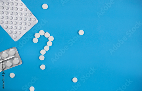 Medical background with multi-colored packs of pills. Сoncept pharmacy, clinic, drugs, headache medicine. Image on illness, flu, treatment. White question mark from pills