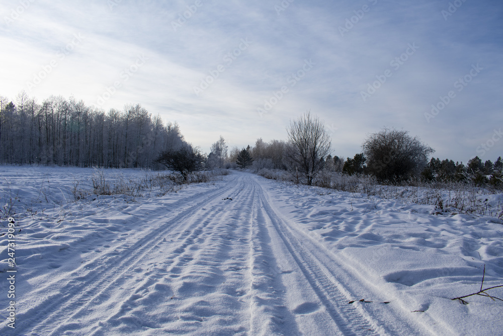 Winter road covered with snow near the village