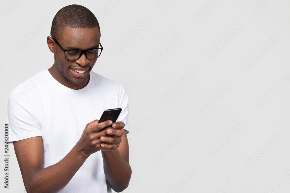cigar synonymordbog Samle Smiling black young man in glasses holding phone looking at smartphone  isolated on white grey studio background with copy space aside, happy  african guy using mobile applications texting on cellphone Stock Photo 