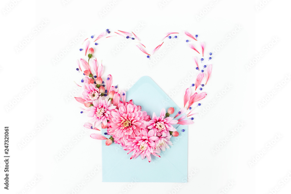 Beautiful floral arrangements. Pink chrysanthemums in the shape of heart with envelope on white background. Flat lay, top view.