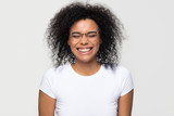 Funny african woman wearing glasses laughing at humor joke isolated on white grey studio background, happy cute black girl with afro hair having fun feeling joy enjoy laughter and positive emotions